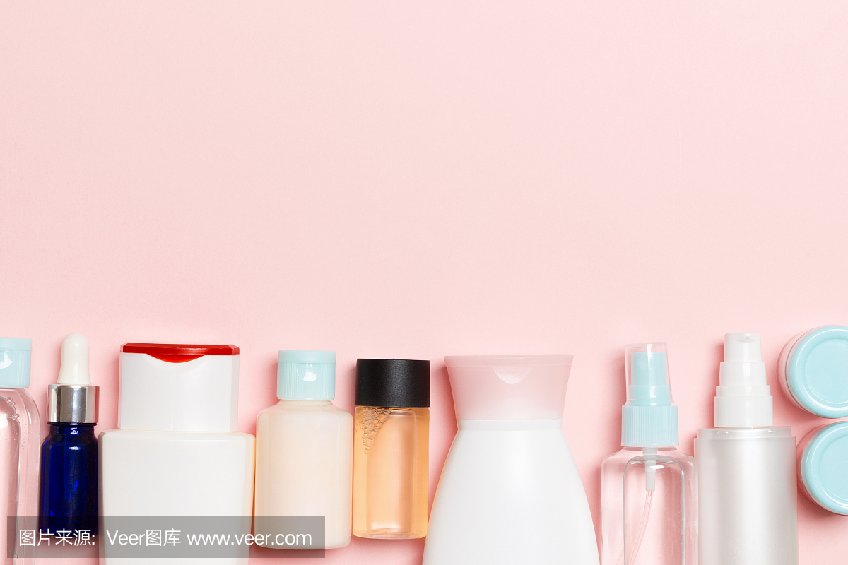 俯视图的化妆品瓶在粉红色的背景。护肤理念与空间为您设计